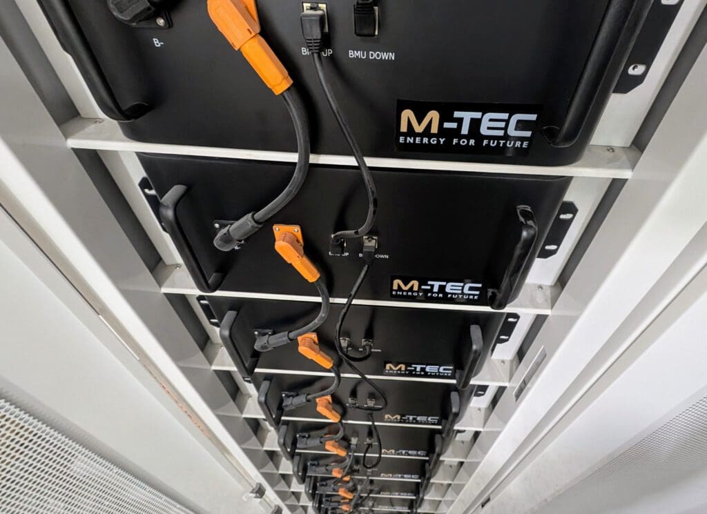 Piccoli blocchi neri con fili collegati e posizionati l'uno sull'altro. Ogni blocco presenta il logo M-TEC.